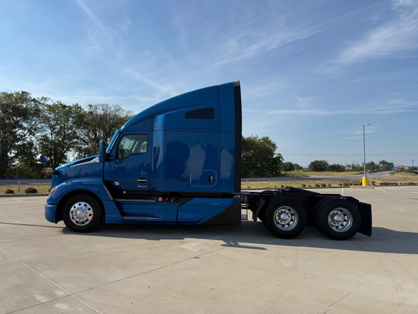 Kenworth T680 tractor in blue cab side profile showing sleeper, 6x4 axle configuration, and chrome wheels.