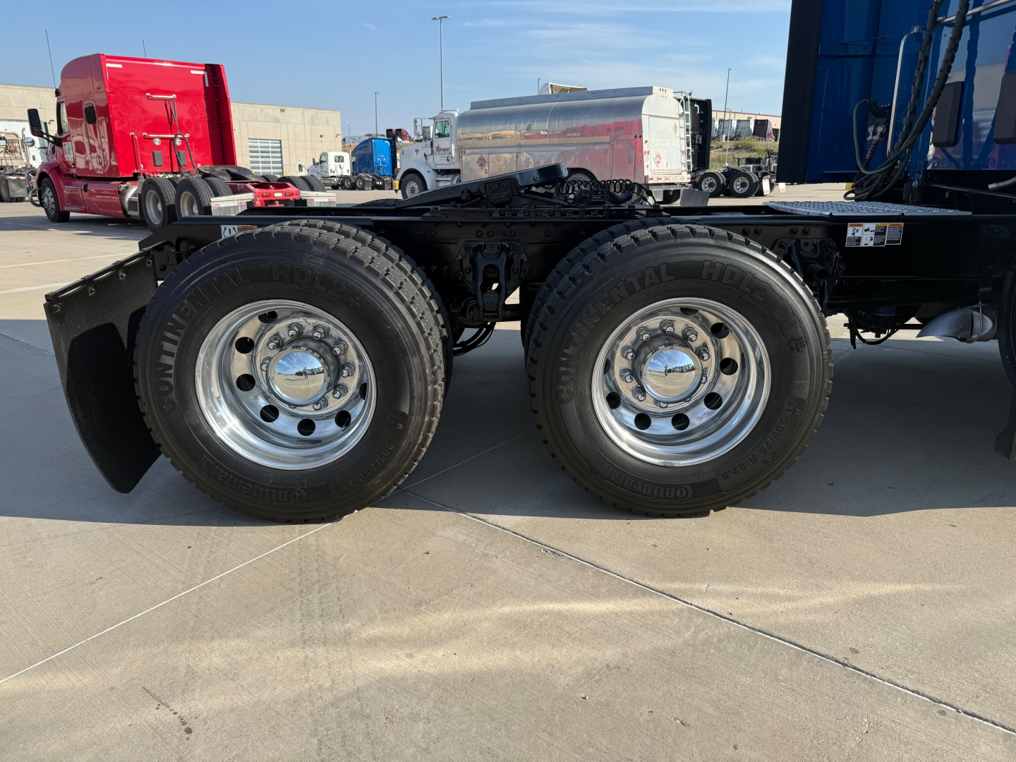 Kenworth T680 truck dual rear wheels and chassis showing wheels and tires in a truck yard.