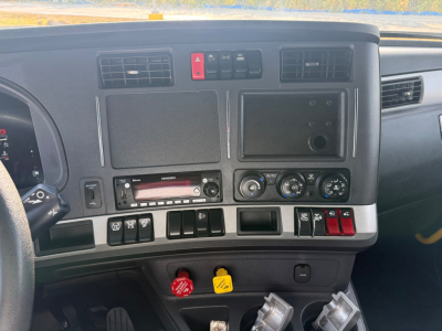 Kenworth T680 dashboard view showing climate controls, radio, and auxiliary switches. VIN and stock not visible on this panel.