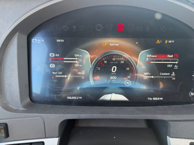 Kenworth T680 digital instrument cluster display showing fuel, coolant, oil, and air gauges with warning indicators; odometer and trip readouts visible.