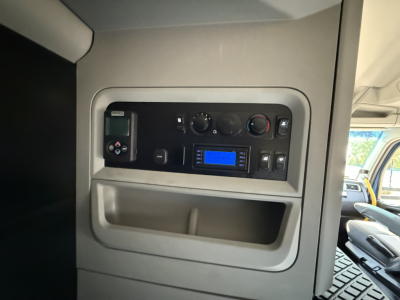 Kenworth T680 interior dashboard panel with blue digital display and control knobs in the sleeper cab area.