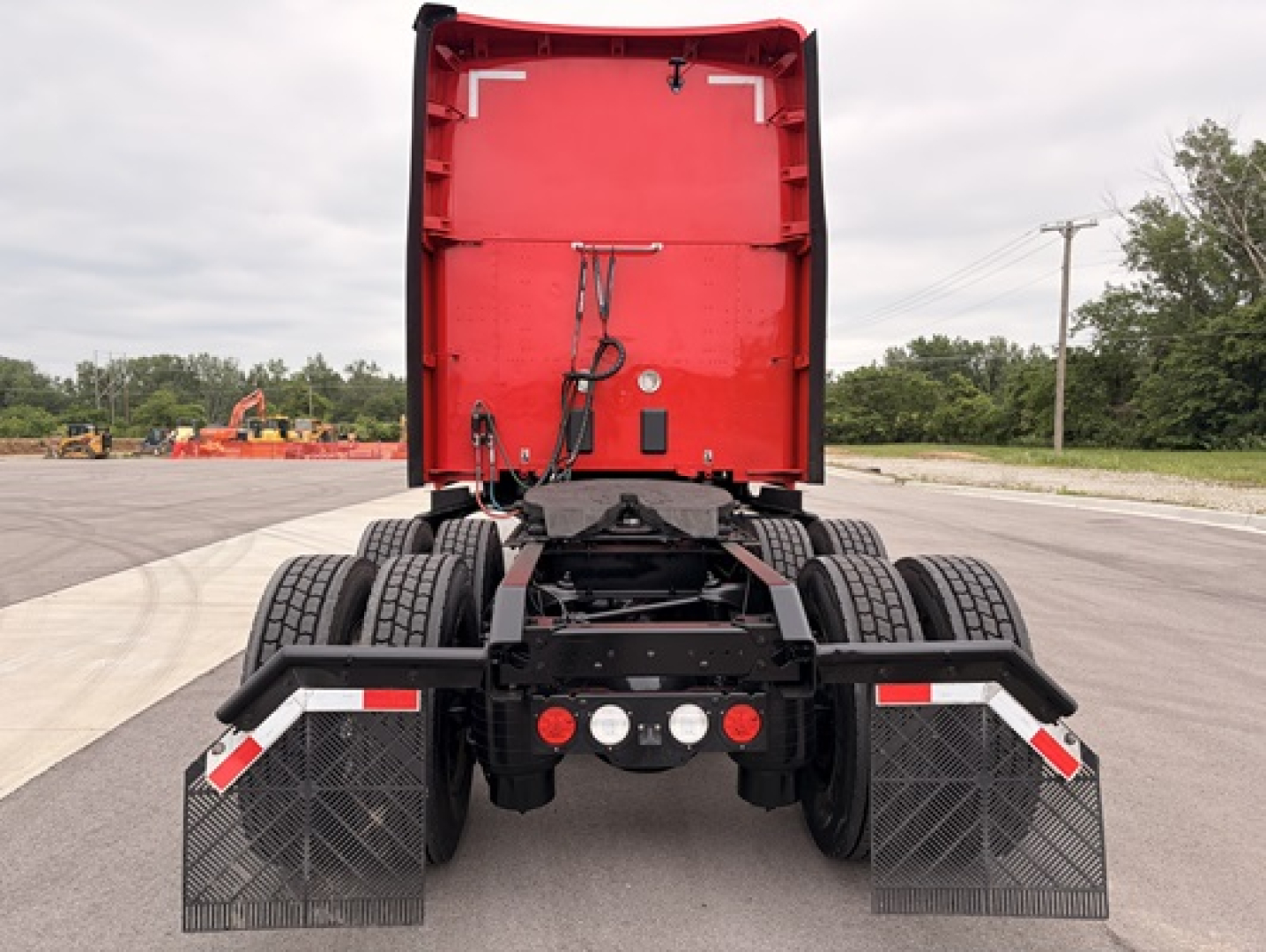 Kenworth T680 rear view showing fifth wheel area and dual rear axles with mud flaps and reflectors.