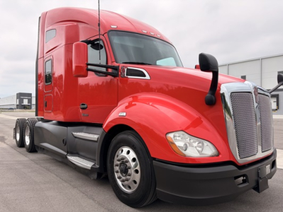 Kenworth T680 tractor in red, front three-quarter view showing cab, grille, headlights, and side mirrors.