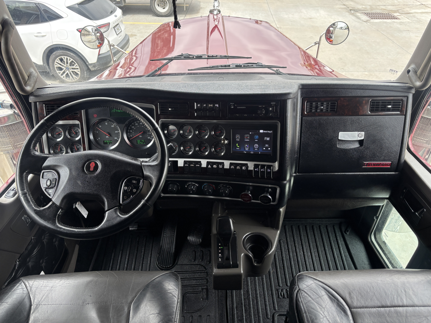 Kenworth W900L cab interior showing dashboard gauges and steering wheel.