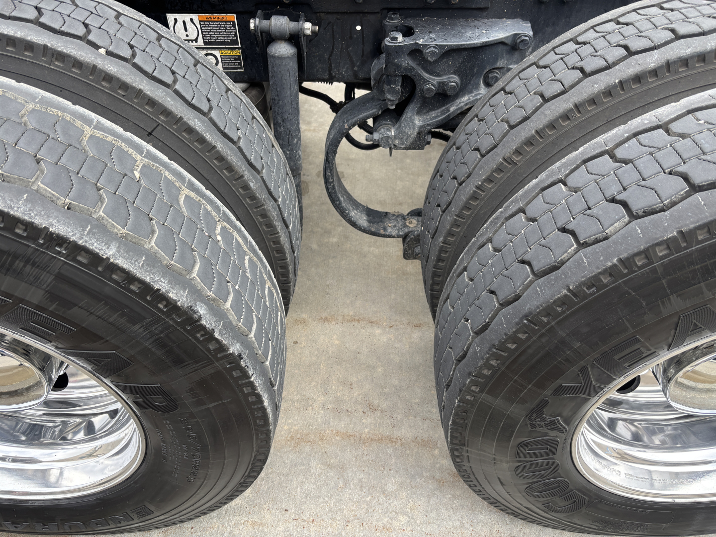 Kenworth W900L truck dual rear axles and drivetrain undercarriage showing tires and suspension components