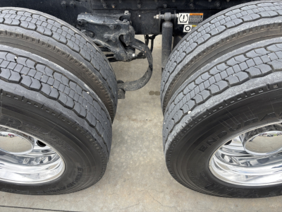 Kenworth W900L front dual rear drive tires and suspension undercarriage with chrome wheels.