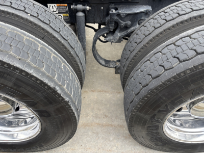 Kenworth W900L truck dual rear axles and drivetrain undercarriage showing tires and suspension components