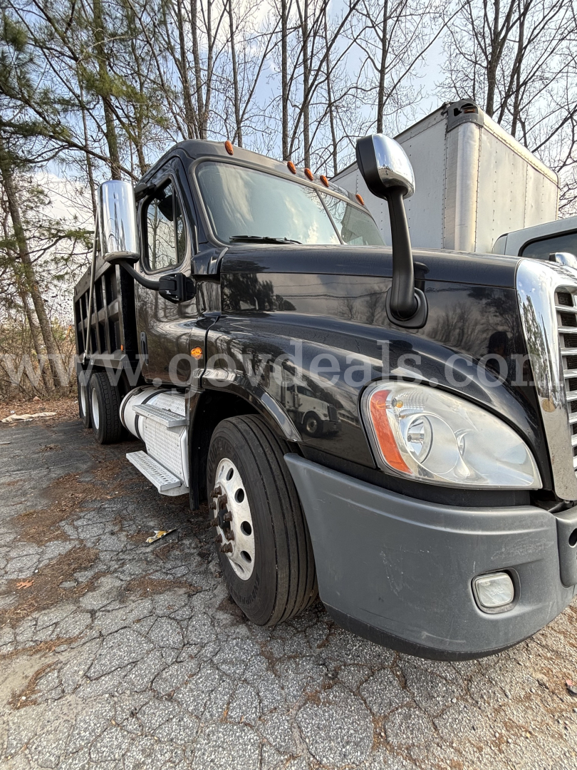 Truck front-left view showing 2018 Freightliner Cascadia 125 dump truck with black body and chrome exhaust stacks.