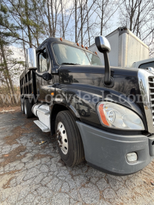 Truck front-left view showing 2018 Freightliner Cascadia 125 dump truck with black body and chrome exhaust stacks.