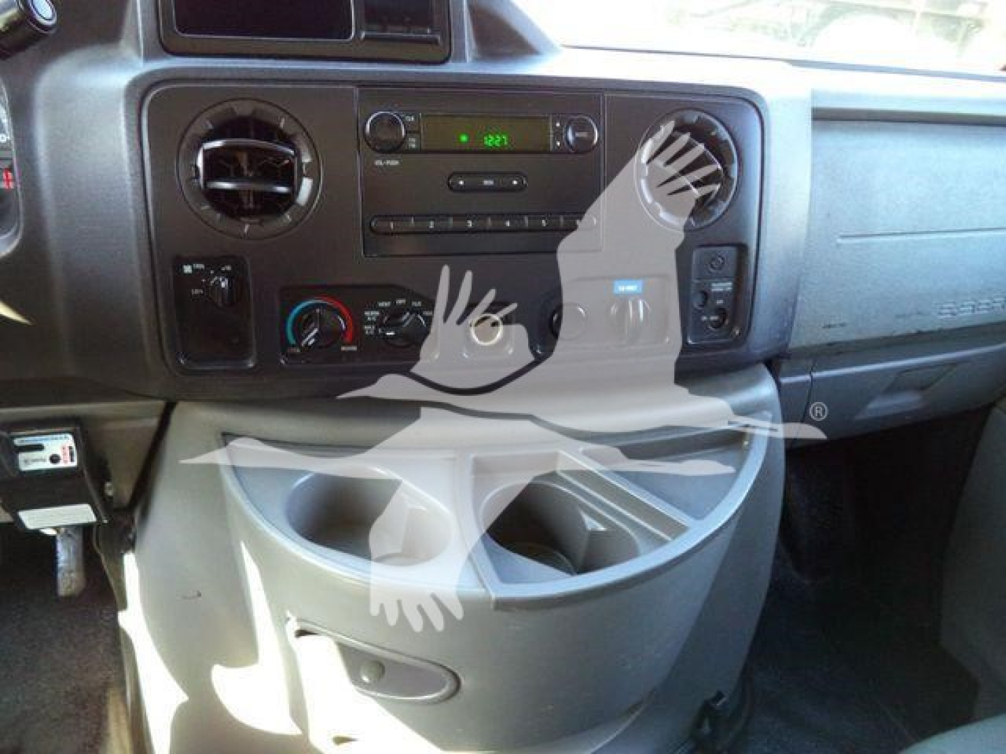 Dashboard of a Ford E-450 cargo/dump truck showing center console with radio, climate controls, and cup holders; no specific textual labels visible beyond standard controls.