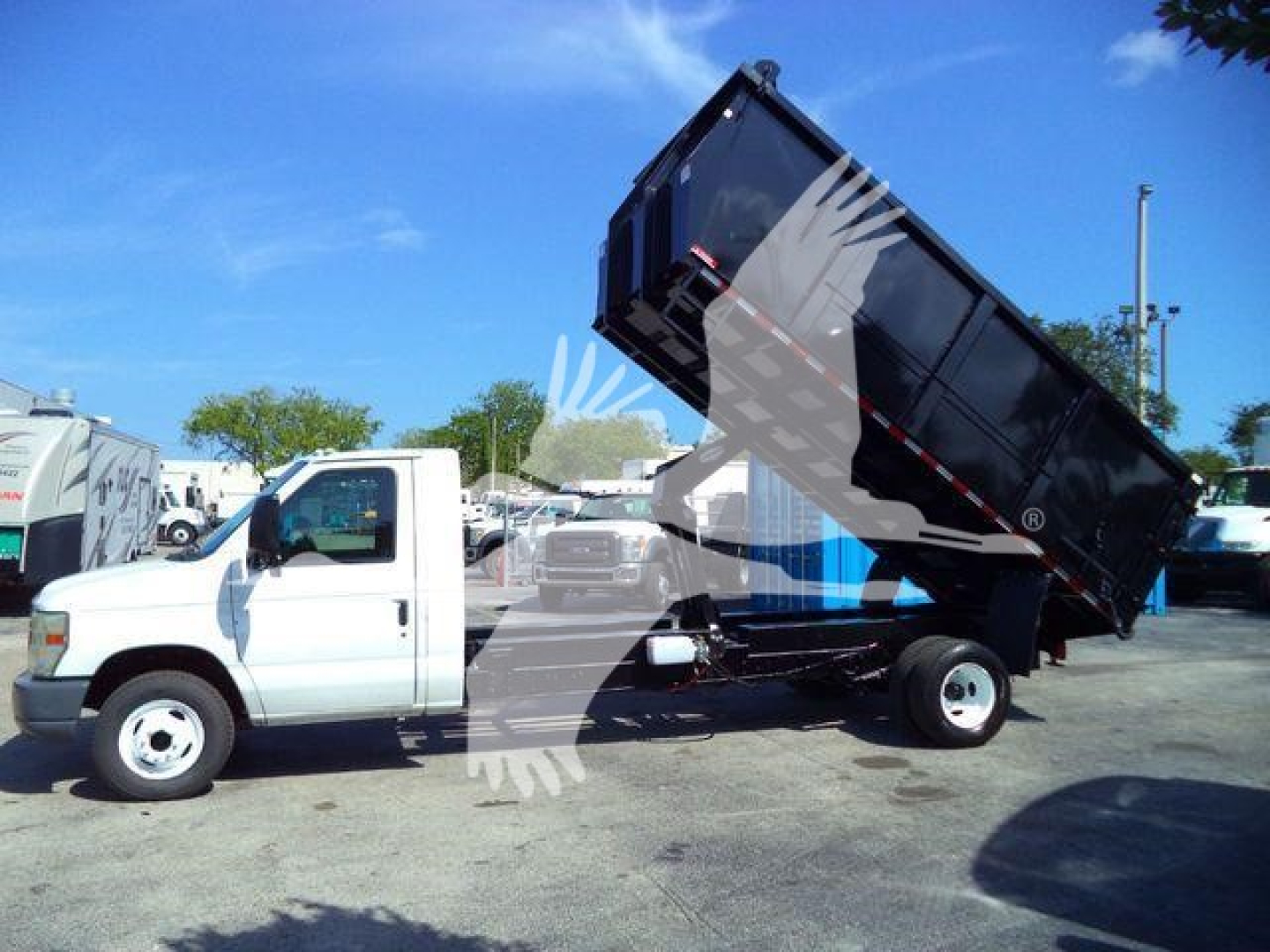 2011 Ford E450 dump truck with hydraulic bed raised, white cab and black dump body. Stock number T57118 PB, category Dump, type Trucks, used.