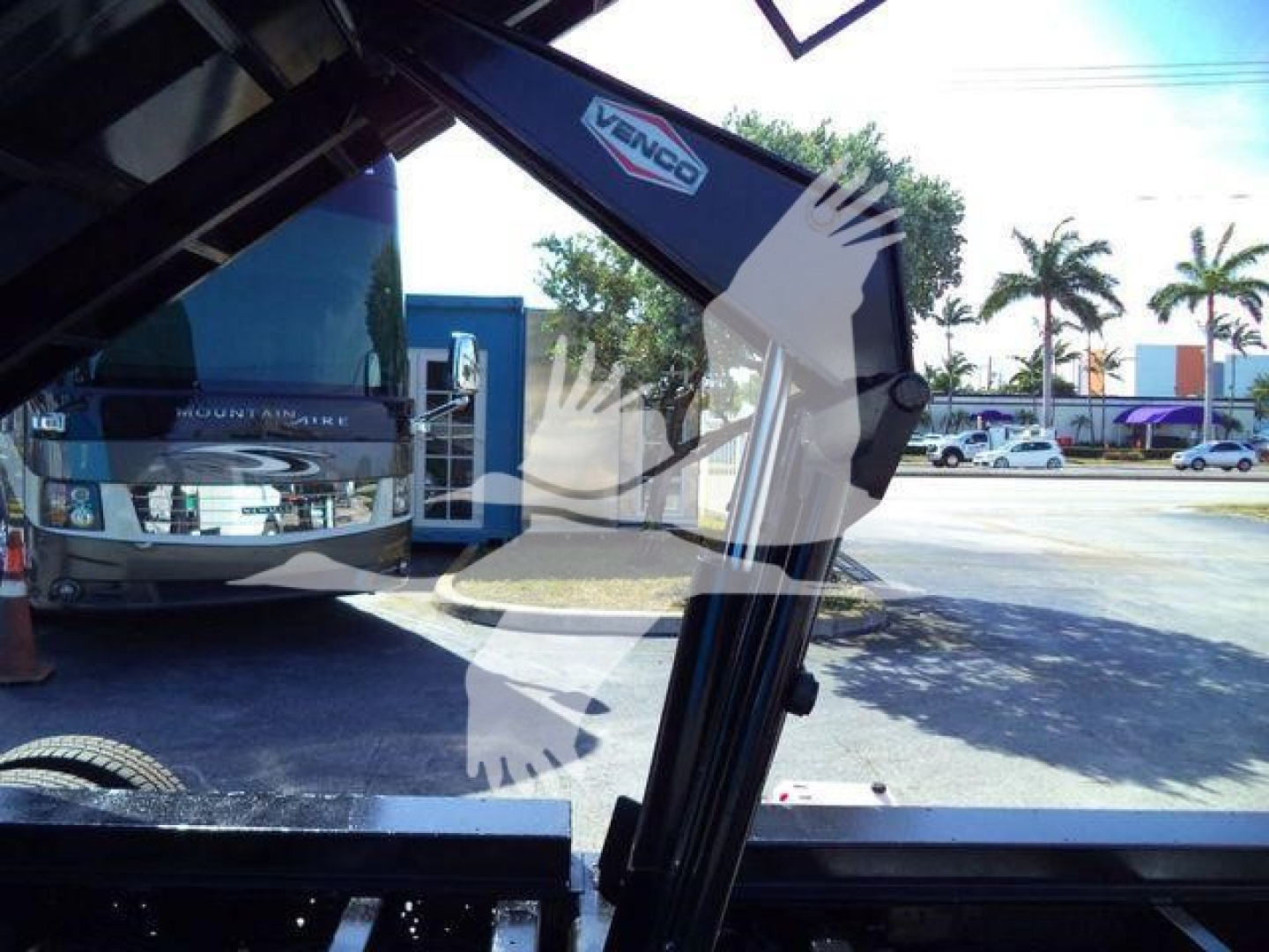 Ford E-450 dump truck arm/crane component with Venco branding visible, side view of hydraulic arm in service position.