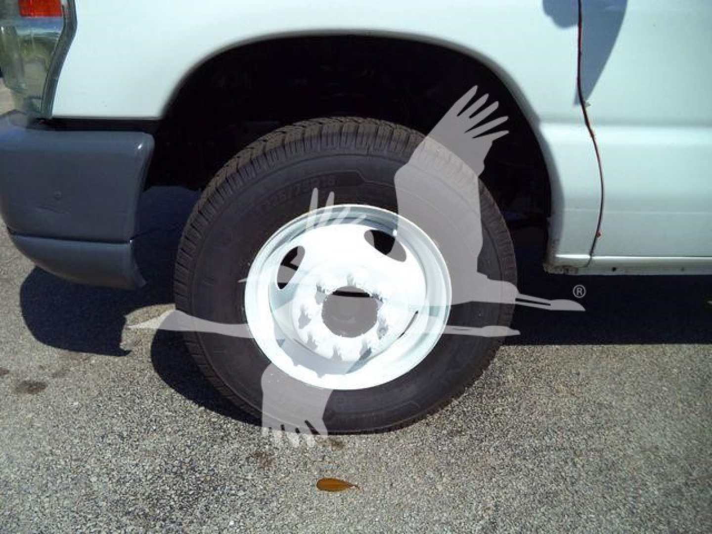 Ford E-450 dump truck front wheel well and tire visible.