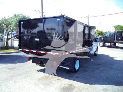 2011 Ford E450 dump truck with a black dump body, rear view showing hitch, rear lights, and side dual wheels.