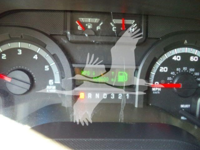 Dashboard view of a Ford E-450 cargo/truck showing gauge cluster, fuel gauge, speedometer, and gear indicator with letters R N D 3 2 1; digital display shows MPH and fuel icon.