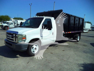 Ford E-450 dump truck with white cab and black dumping bed, side view showing front grille and dual rear wheels; stock number visible in listing as T57118 PB.