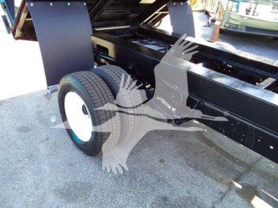 Ford E450 dump truck chassis showing rear dual wheels and metal frame components.