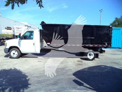 Ford E450 dump truck side view showing black dump bed and white cab with stock number T57118 PB label.