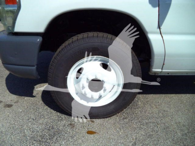 Ford E-450 dump truck front wheel well and tire visible.
