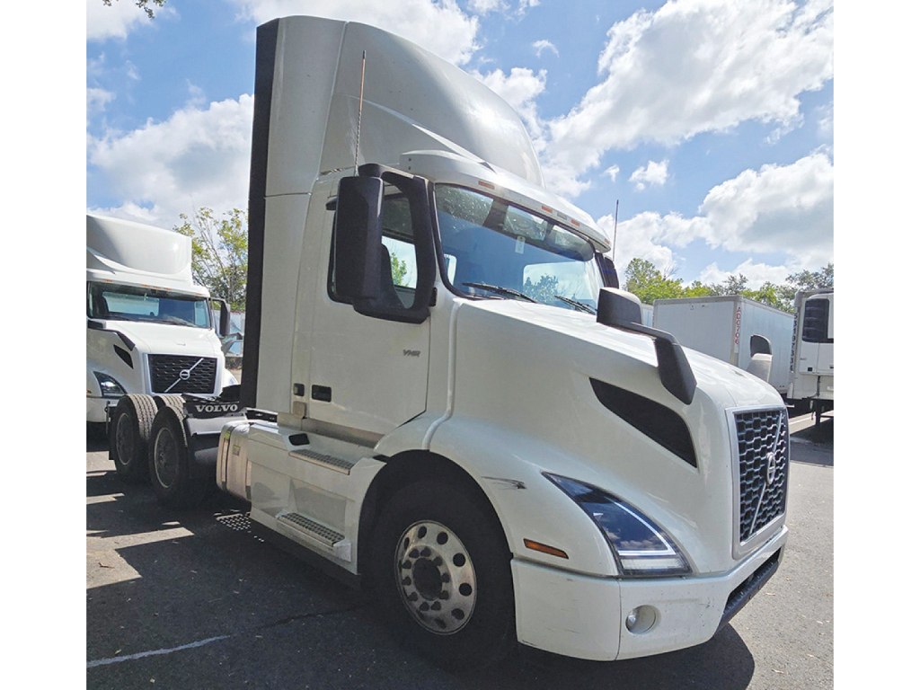 Truck cab of a 2022 Volvo VNR 300 in white, front angled view showing aerodynamic hood, side mirror, and grille.