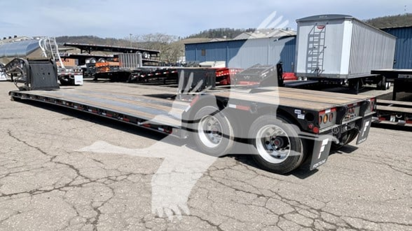 Fontaine Renegade N12 lowboy trailer side view showing long flat deck, dual axles at rear, tandem wheels, rear lighting, and gooseneck connection visible.