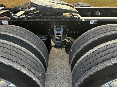 Kenworth truck chassis drivetrain area with dual rear axles and fifth-wheel mounting plate visible. No readable labels or fluid specs.