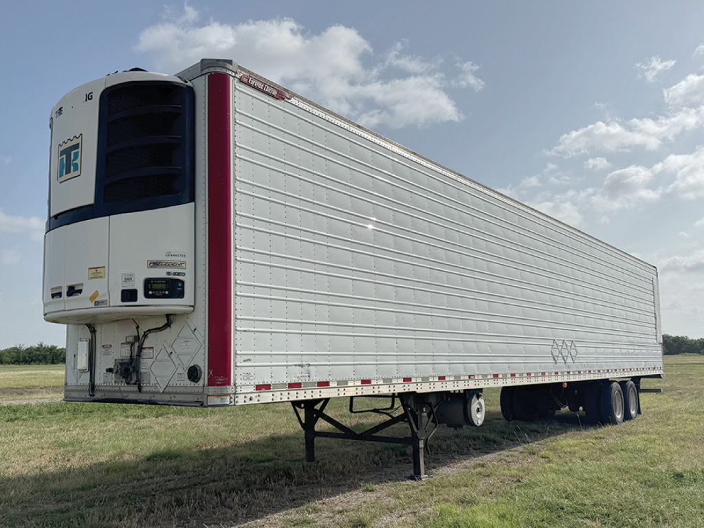 Great Dane Everest SS trailer side view showing refrigeration unit at front with KW129521 VIN and stock tag; reefer trailer undercarriage and support legs visible.