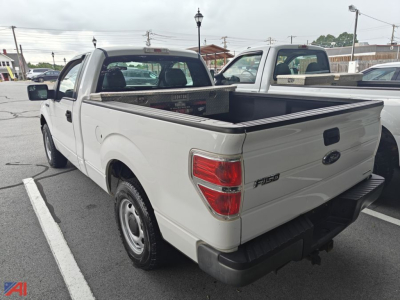 Ford F-150 pickup truck in white with flatbed bed and cargo rack, rear and passenger-side view