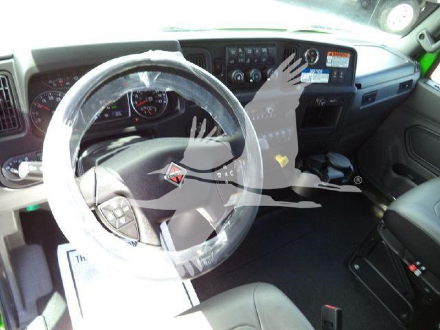 Truck interior showing steering wheel and dashboard of a 2027 International MV rollback truck.