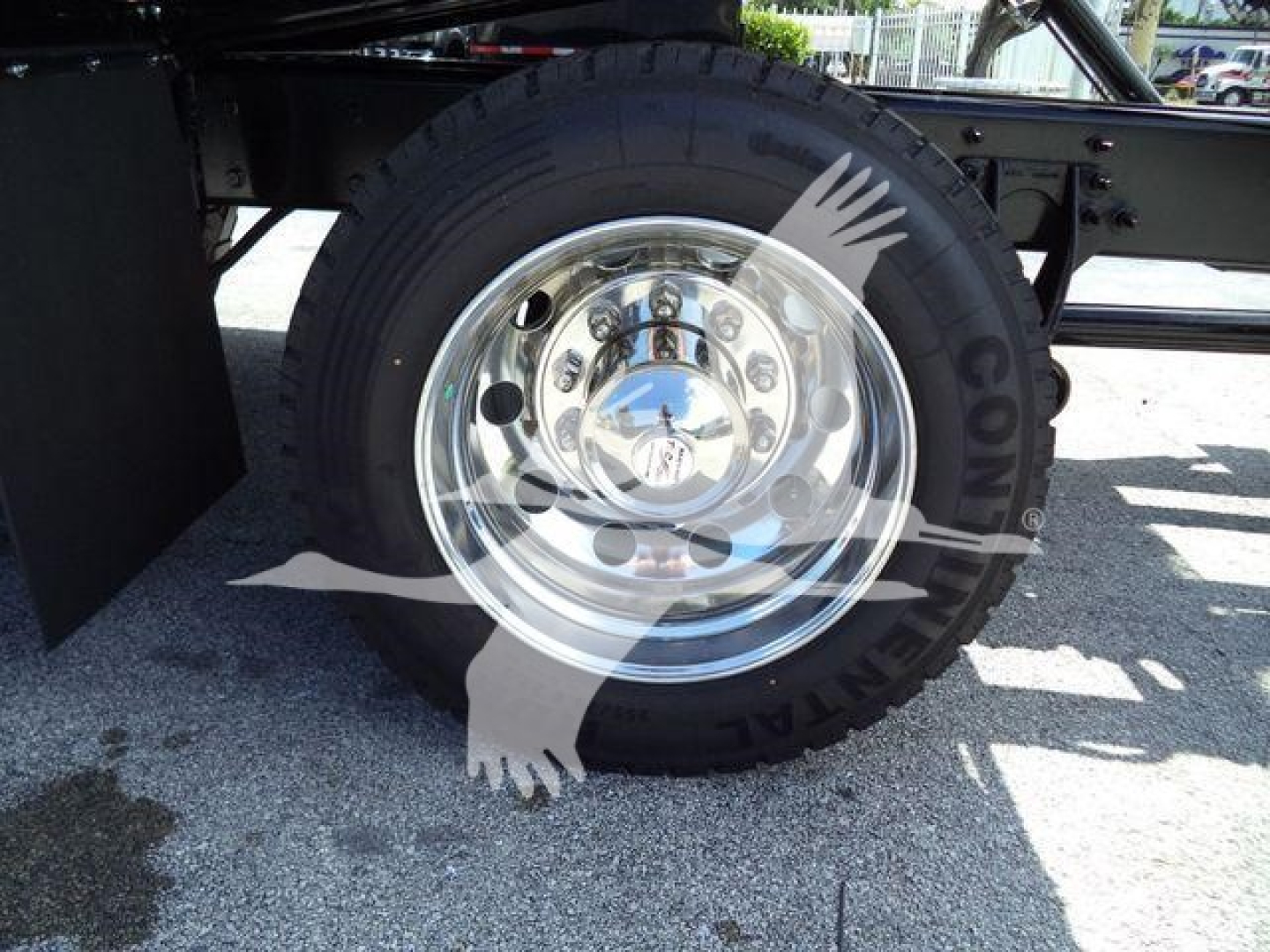 Wheel and chrome hubcap on a truck with reflective surface showing lug nuts and tire treads.
