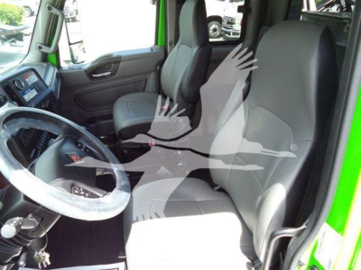 Interior of a green 2027 International MV truck showing front seats, steering wheel, and dashboard.