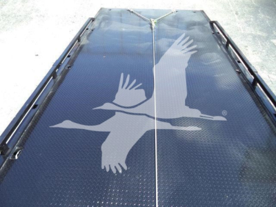 Flatbed truck deck with a large white bird graphic in flight. Visible anti-slip diamond plate surface and side rails along the edges.