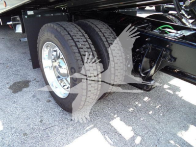 Truck rear dual wheels and suspension undercarriage showing dual tires, chrome wheel, and chassis frame.