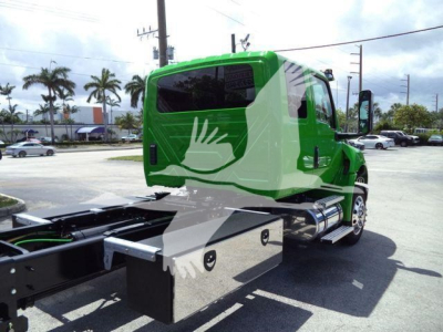 Green International MV rollback truck cab showing side fuel tanks and chassis, with stock number J24111 on listing.