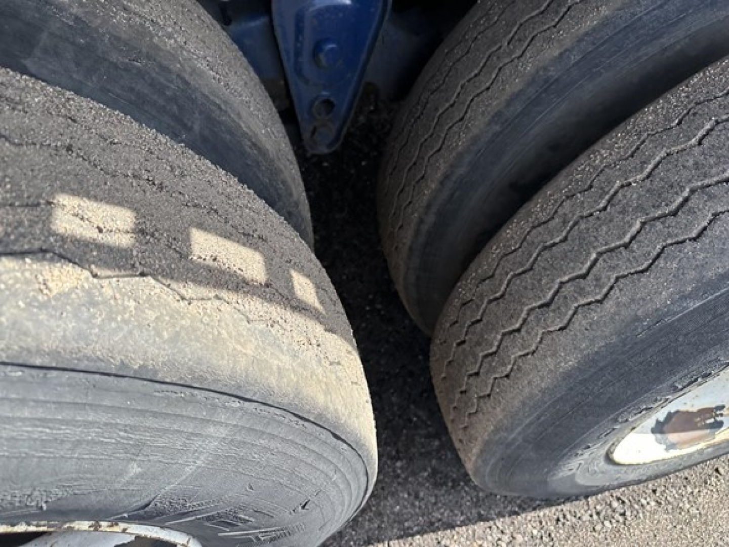Close-up view of trailer tires showing tread wear and dual wheels on a Transcraft flatbed trailer.