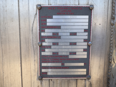 Metal data plate on trailer with multiple fields including MFG BY TRAVIS BROS & TRAILER CO., HOUSTON TX, VIN, GVR, GAWR, GAWR INTERMODAL, WHEELBASE, and other blank/form fields.