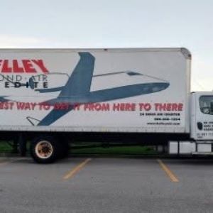 Truck trailer side with Freightliner logo and graphic art; text appears as part of livery on a Freightliner M2 106 truck.