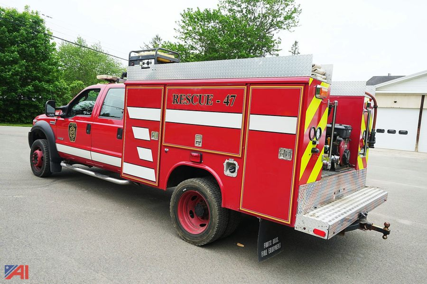 Ford F-550 crew cab fire rescue truck with red body, white reflective stripes, labeled RESCUE-47, rear compartment doors open, pump area exposed.