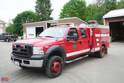 Ford F-550 crew cab fire rescue brush truck in red with equipment compartments and emergency lights.