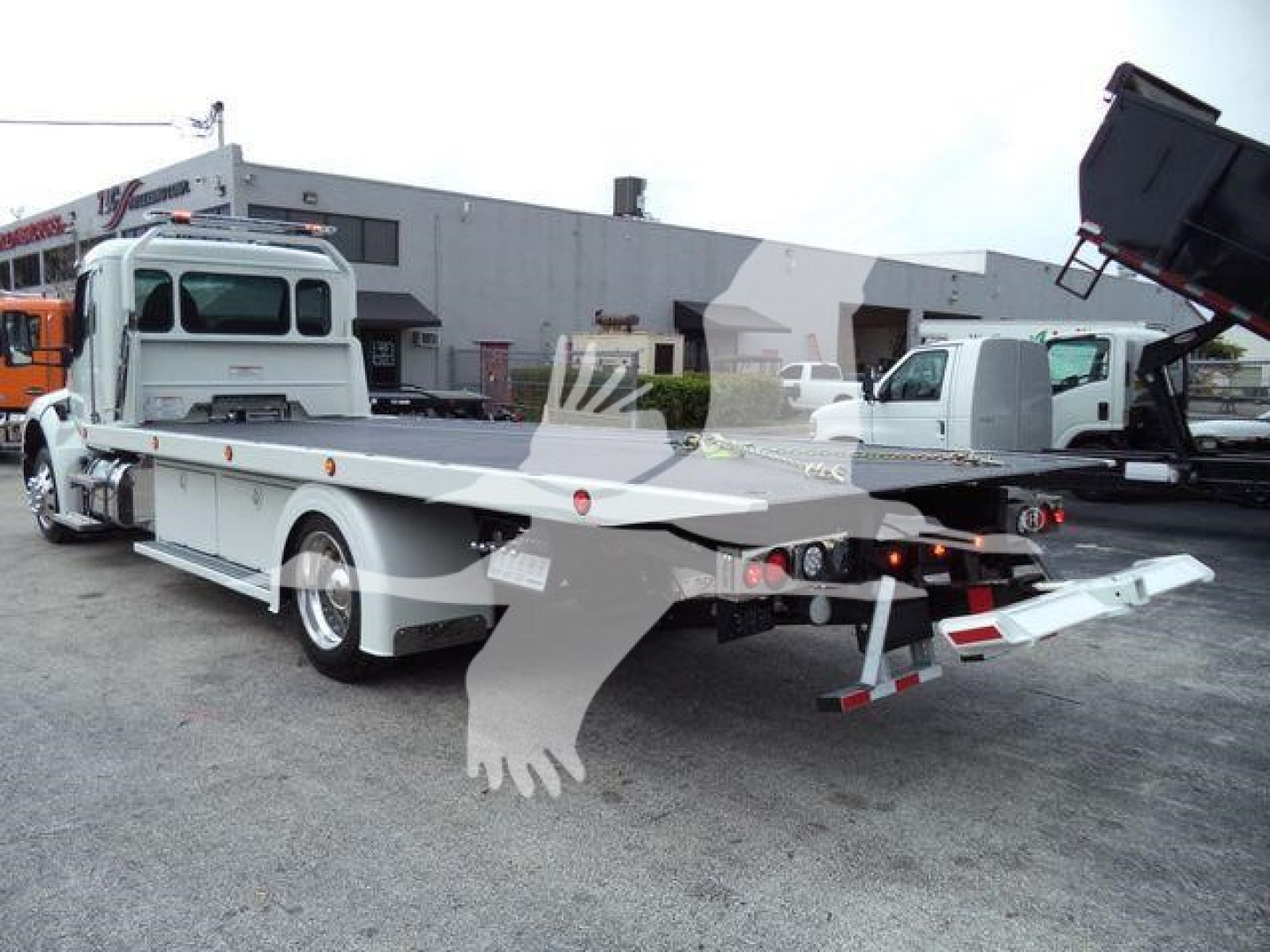 Kenworth T280 rollback truck rear quarter view showing flatbed and rear ramps.