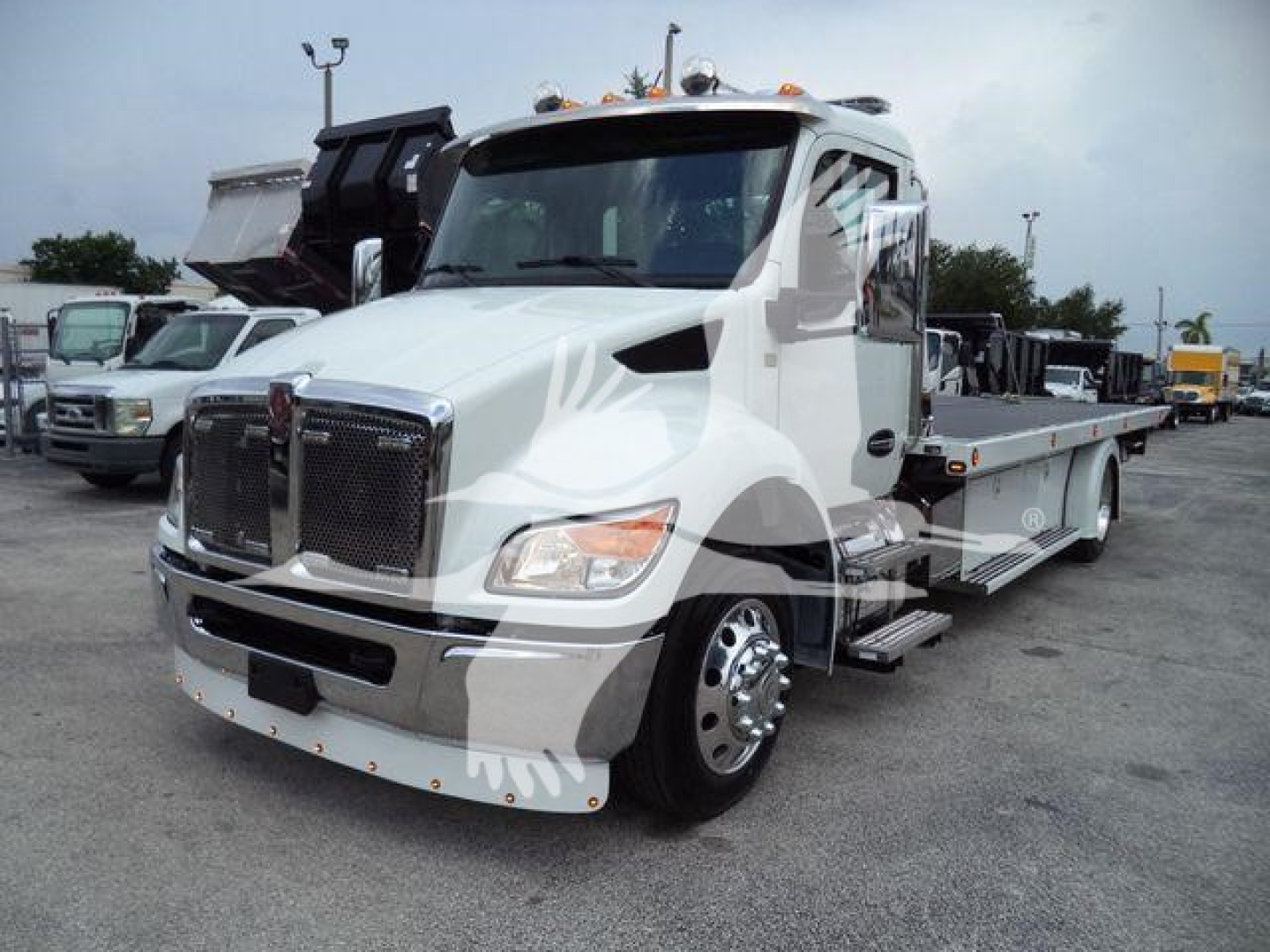 Kenworth T280 rollback tow truck in white showing front grille, cab, and flatbed bed with stepside white markers.