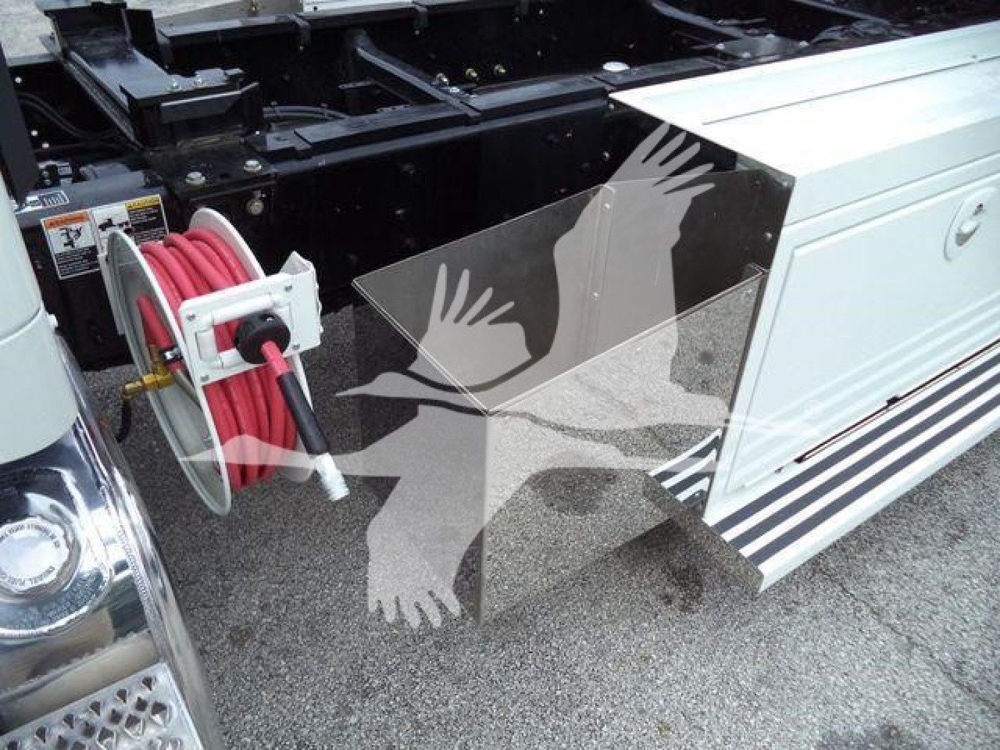 Kenworth T280 rollback chassis with hose reel and storage box visible on side, side view showing equipment mount and paneling