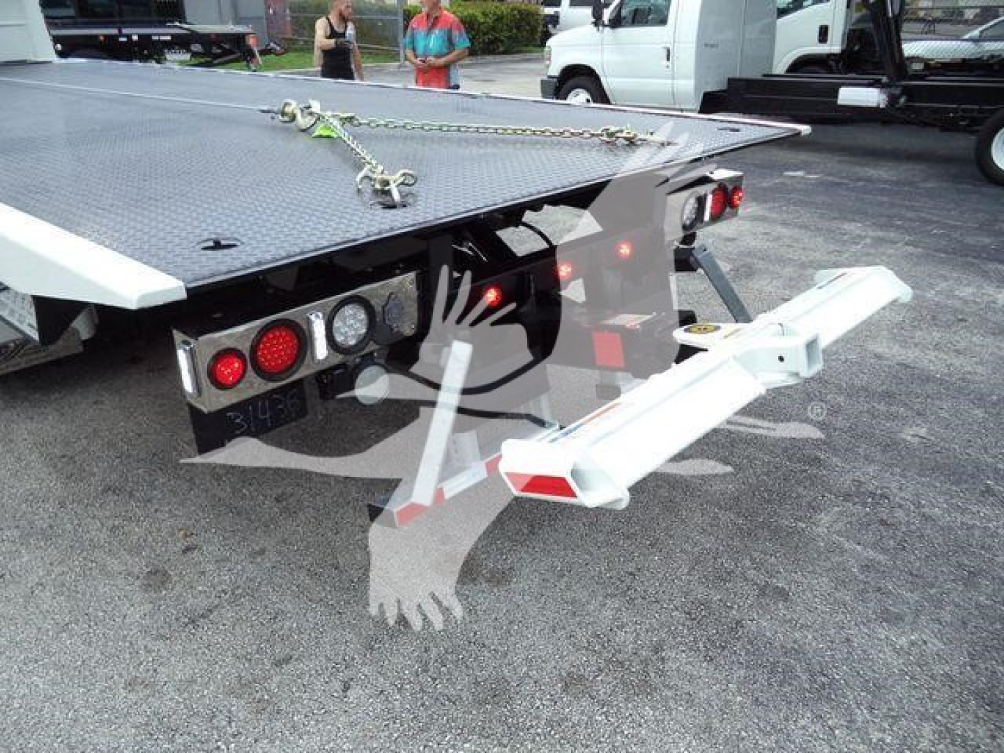 Kenworth T280 rollback truck rear with loading ramp and chain setup, trailer hitch, and dual taillights on a flatbed.
