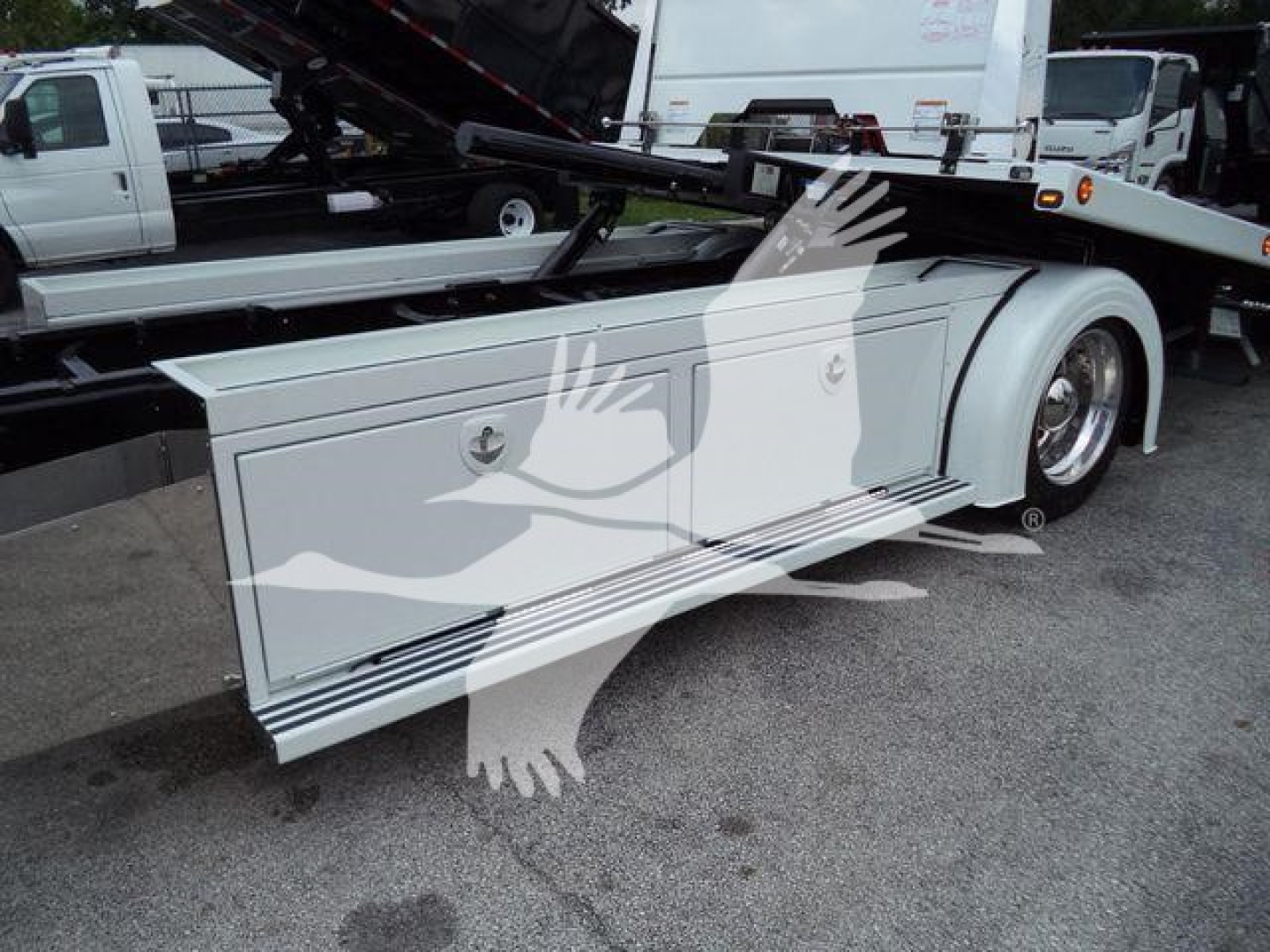 Kenworth T280 rollback truck side storage drawer and wheel well, white storage compartment with handle, hydraulic lift in background, side profile view.