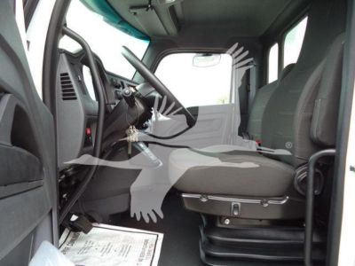 Truck cab interior showing steering wheel and driver seat of a Kenworth T270/T280, with dashboard controls visible