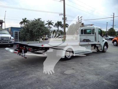 Kenworth T280 rollback tow truck side view showing flatbed with hydraulic cradle and truck cab in light color.