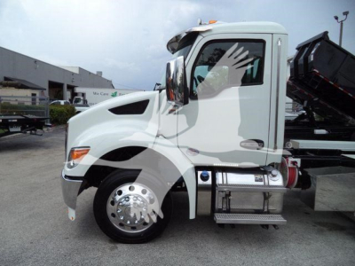 Kenworth T280 roll-off truck side view showing cab, front wheel, and fuel tank.
