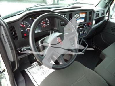 Dashboard and steering wheel of a Kenworth truck cab with instrument cluster, steering wheel emblem, and center console controls.