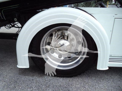 Wheel well and fender of a Kenworth T280 truck showing chrome wheel with hub and surrounding white fender cover.