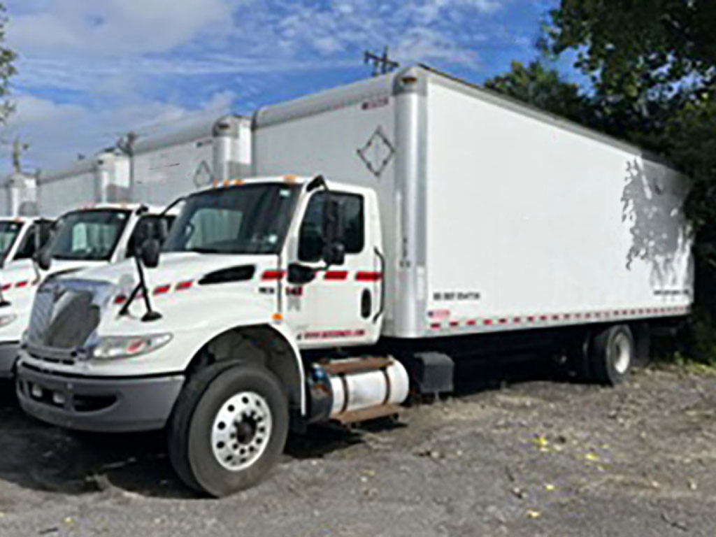 Truck underbody and cargo box with International MV series cab-front, dual rear wheels, and a white refrigerated box.